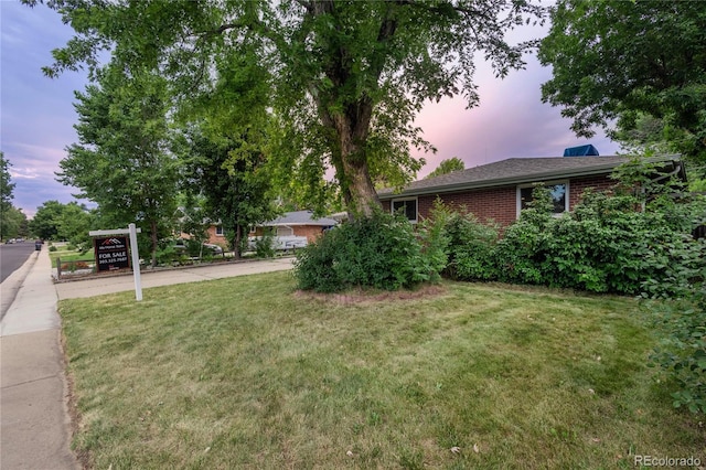 6077 Flower St, Arvada, CO 80004 - yard at dusk featuring a yard and concrete driveway