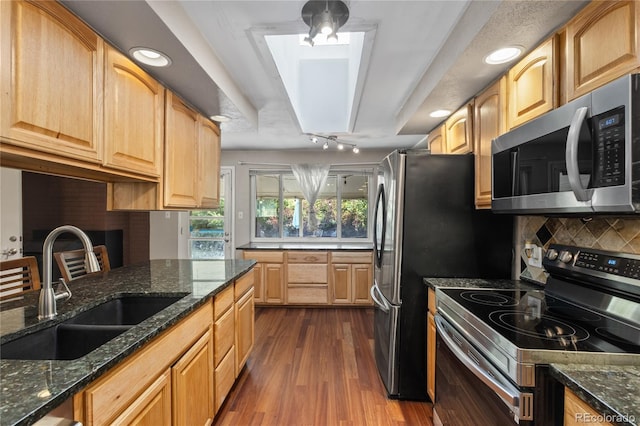 6077 Flower St, Arvada, CO 80004 - kitchen with appliances with stainless steel finishes, dark wood-type flooring, backsplash, dark stone counters, and recessed lighting