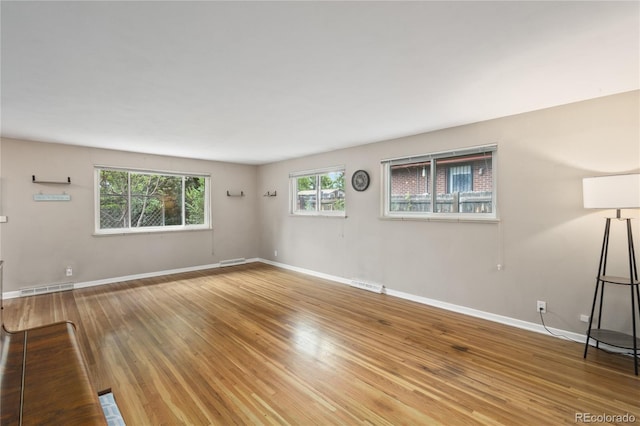 6077 Flower St, Arvada, CO 80004 - unfurnished living room featuring baseboards and wood finished floors