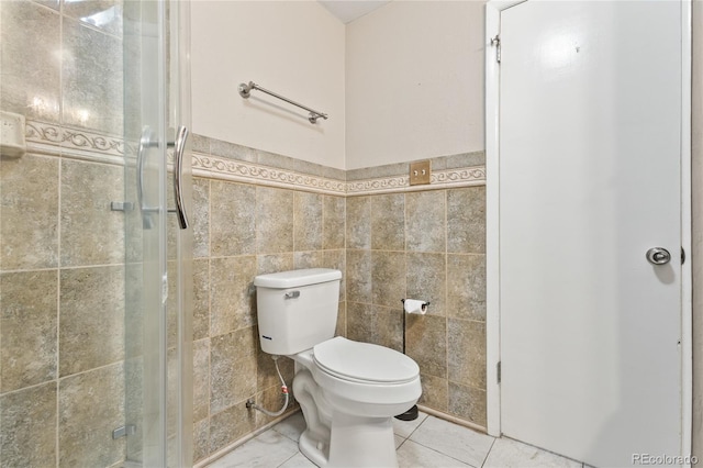 6077 Flower St, Arvada, CO 80004 - full bathroom featuring tile walls, a shower stall, wainscoting, and tile patterned floors