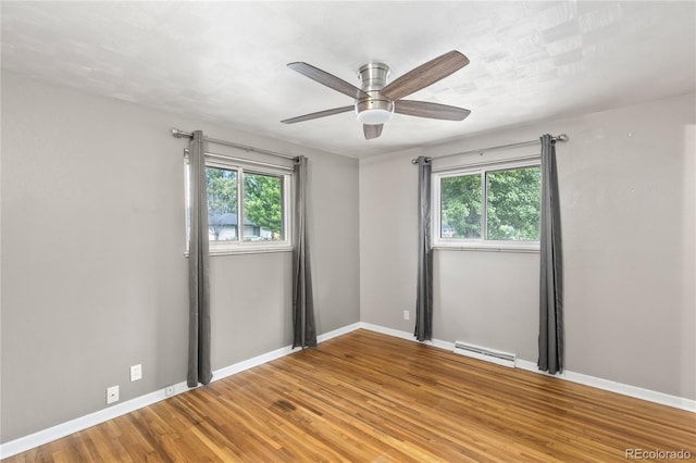 6077 Flower St, Arvada, CO 80004 - unfurnished room featuring baseboard heating, plenty of natural light, wood finished floors, and ceiling fan