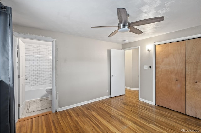6077 Flower St, Arvada, CO 80004 - unfurnished bedroom featuring ensuite bath, wood finished floors, a closet, and a ceiling fan
