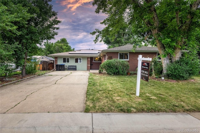 6077 Flower St, Arvada, CO 80004 - view of front of property with solar panels, driveway, and brick siding