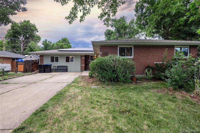 6077 Flower St, Arvada, CO 80004 - view of front facade with solar panels, brick siding, and driveway