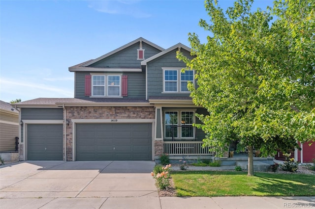 14119 W 89th Loop, Arvada, CO 80005 - craftsman house featuring concrete driveway, a front lawn, a garage, a porch, and stone siding