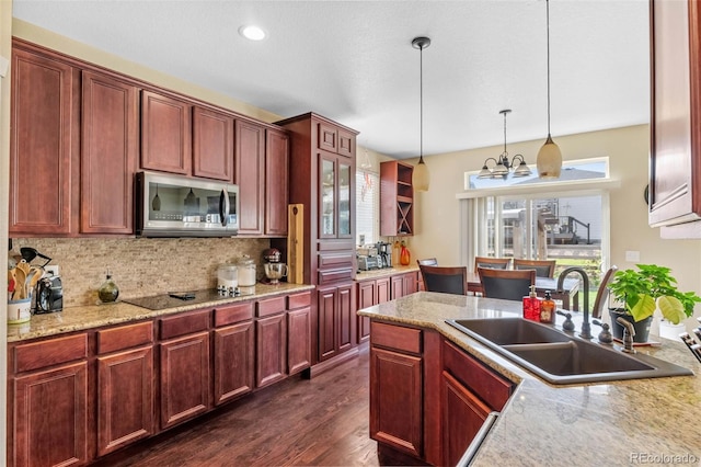 14119 W 89th Loop, Arvada, CO 80005 - kitchen with stainless steel microwave, decorative light fixtures, backsplash, a chandelier, and dark wood-style flooring