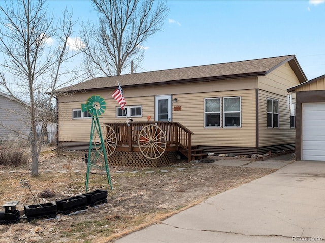 view of front of house with a garage, an outdoor structure, and a wooden deck