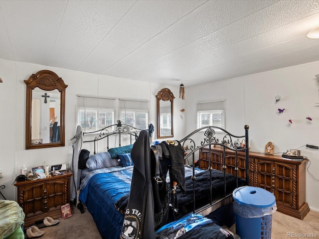 bedroom with multiple windows, carpet, and a textured ceiling