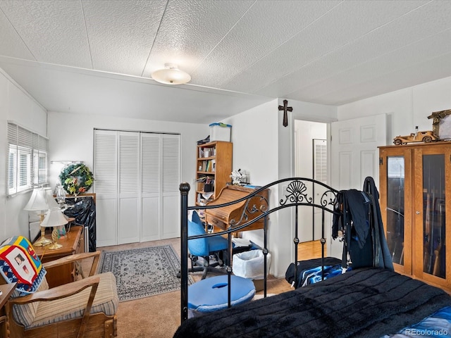 carpeted bedroom featuring a textured ceiling and a closet