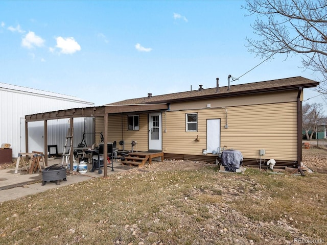 rear view of house with a patio and a fire pit