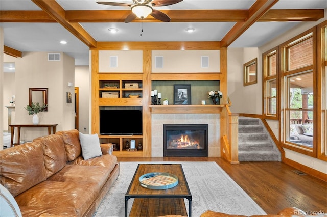 1122 Forest Trails Dr, Castle Pines, CO 80108 - living room with beamed ceiling, wood finished floors, ceiling fan, a tiled fireplace, and coffered ceiling