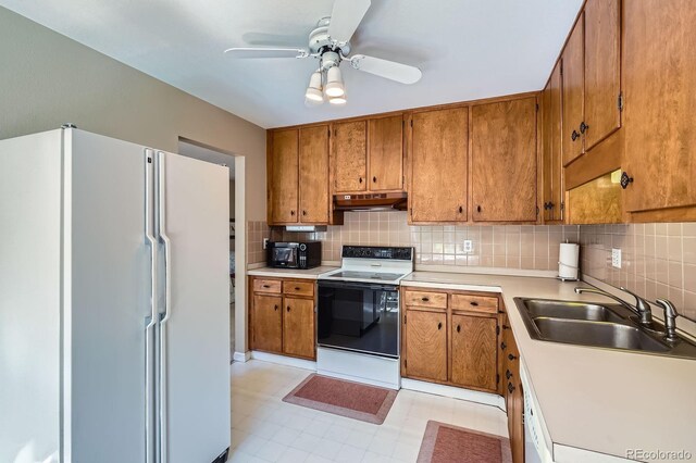 6857 S Franklin Cir, Centennial, CO 80122 - kitchen with freestanding refrigerator, under cabinet range hood, a sink, range with electric stovetop, and brown cabinetry