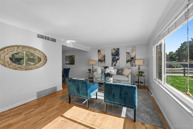 7486 S Washington St, Centennial, CO 80122 - living area featuring wood finished floors, plenty of natural light, and ornamental molding