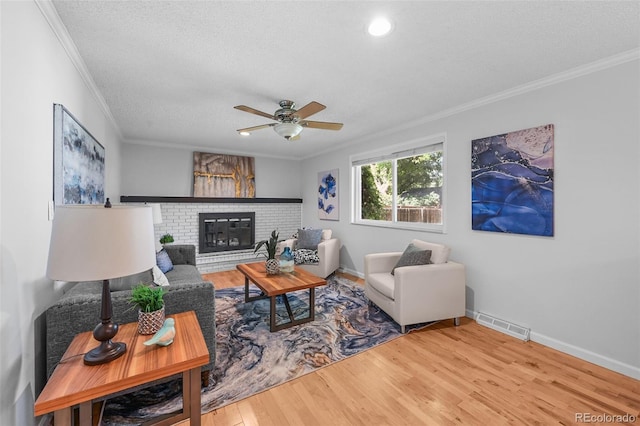 7486 S Washington St, Centennial, CO 80122 - living room featuring ornamental molding, ceiling fan, wood finished floors, a brick fireplace, and a textured ceiling