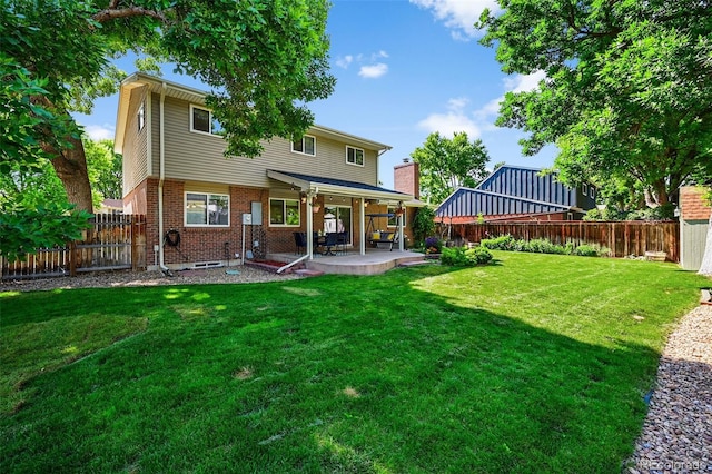 7486 S Washington St, Centennial, CO 80122 - rear view of house with brick siding, a patio, and a fenced backyard