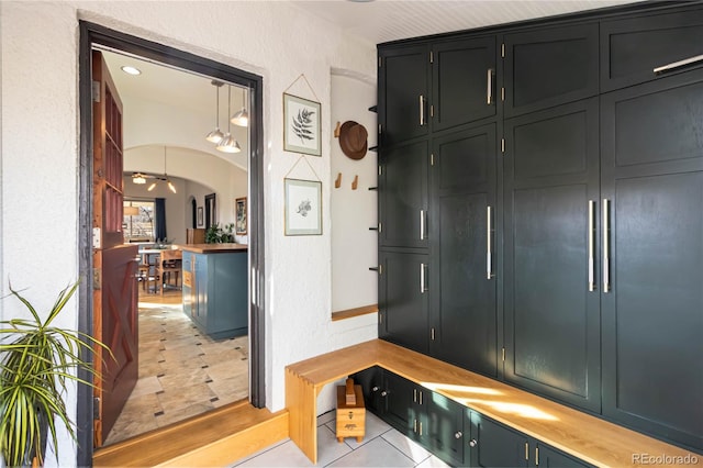 mudroom with light tile patterned floors and arched walkways