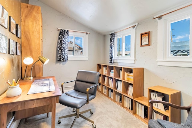 office space featuring vaulted ceiling, a textured wall, and carpet flooring