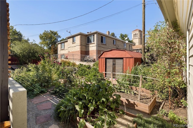 exterior space with an outbuilding, a storage unit, a vegetable garden, and fence