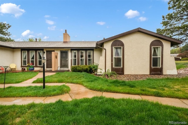 3314 Valley Hi Ave Unit B, Colorado Springs, CO 80910 - view of front of house with a chimney, a front yard, and stucco siding