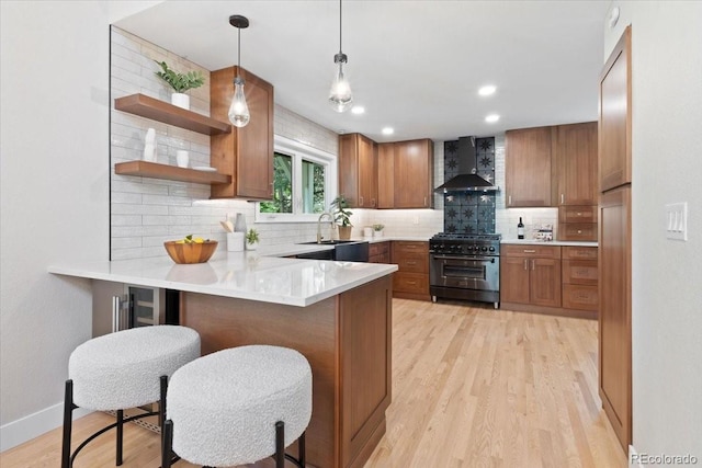 4505 S Yosemite St Unit 362, Denver, CO 80237 - kitchen with high end range, wall chimney exhaust hood, brown cabinetry, tasteful backsplash, and a peninsula
