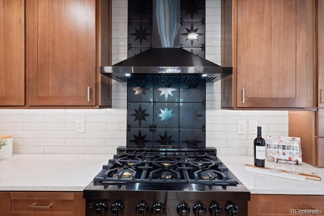 4505 S Yosemite St Unit 362, Denver, CO 80237 - kitchen featuring wall chimney range hood, stainless steel gas stovetop, brown cabinets, and backsplash