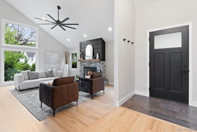 4505 S Yosemite St Unit 362, Denver, CO 80237 - living area featuring high vaulted ceiling, ceiling fan, wood finished floors, a fireplace, and baseboards