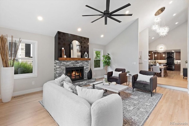 4505 S Yosemite St Unit 362, Denver, CO 80237 - living room with a fireplace, light wood finished floors, baseboards, ceiling fan, and a chandelier