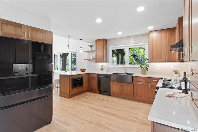 4505 S Yosemite St Unit 362, Denver, CO 80237 - kitchen featuring black appliances, a peninsula, decorative backsplash, brown cabinets, and light countertops