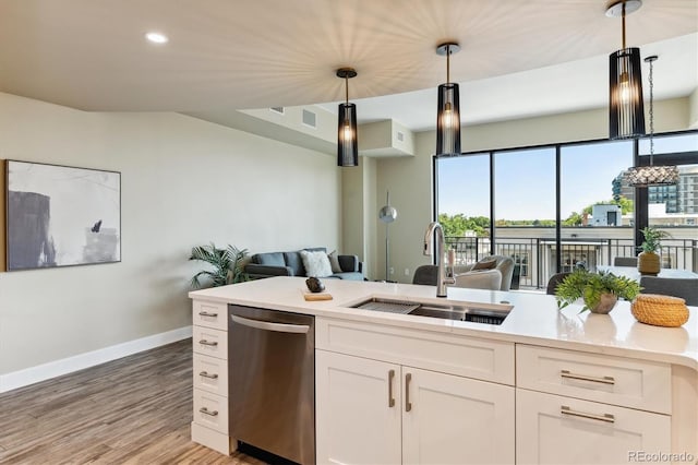 kitchen with sink, light hardwood / wood-style flooring, dishwasher, white cabinetry, and hanging light fixtures