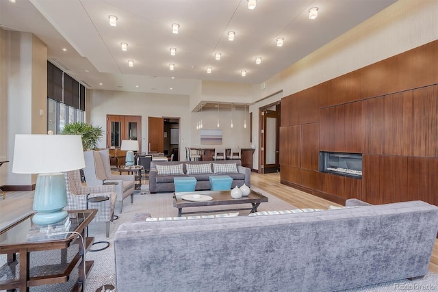 living room with light hardwood / wood-style flooring and a high ceiling