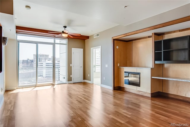 unfurnished living room with ceiling fan and hardwood / wood-style floors