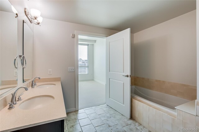 bathroom with vanity, tiled tub, and tile patterned floors