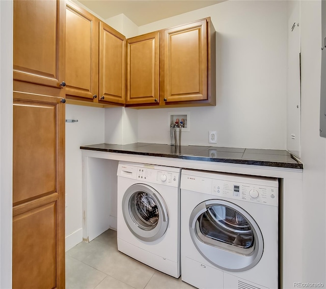 laundry room with independent washer and dryer, cabinets, and light tile patterned floors