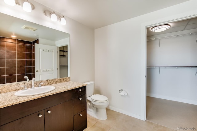 bathroom with toilet, vanity, and tile patterned floors