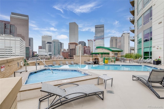 view of swimming pool featuring a community hot tub and a patio