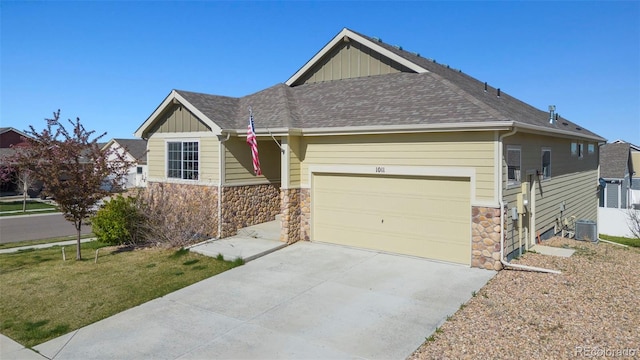 view of front facade featuring a front yard, a garage, and central AC