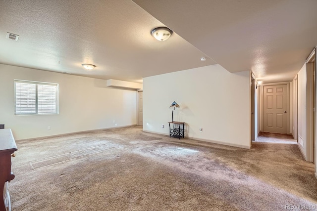 unfurnished living room featuring carpet and a textured ceiling