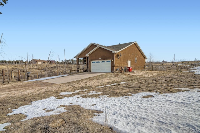 view of side of home with a garage and a rural view