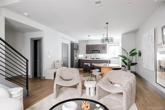 living room with light hardwood / wood-style floors and sink