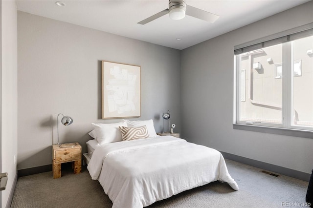 carpeted bedroom with ceiling fan and multiple windows