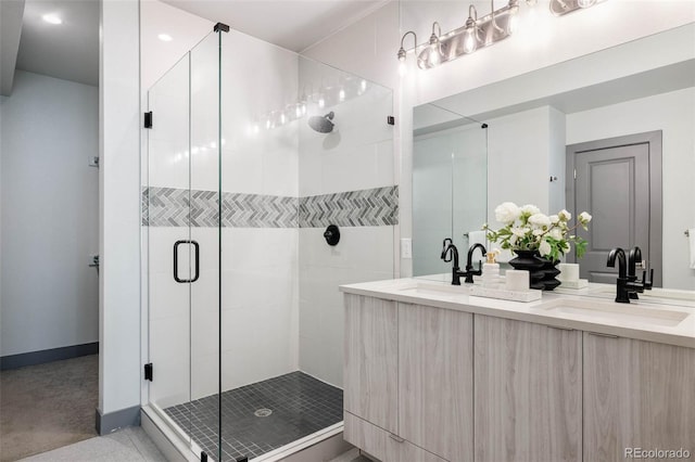 bathroom with vanity and a shower with door