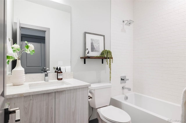 full bathroom featuring toilet, vanity, and tiled shower / bath