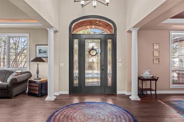 entrance foyer featuring a healthy amount of sunlight, decorative columns, and hardwood / wood-style floors