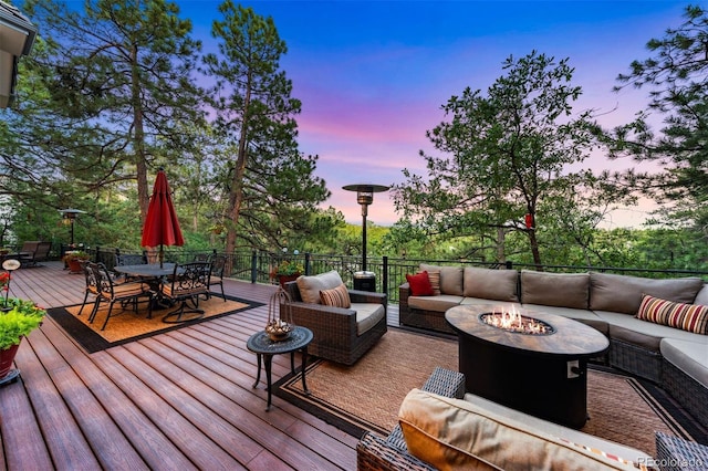 deck featuring outdoor dining area and an outdoor living space with a fire pit