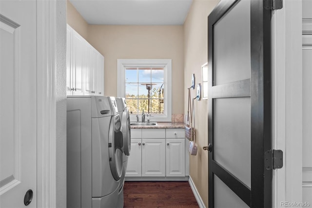 washroom featuring dark wood-style floors, cabinet space, a sink, and separate washer and dryer