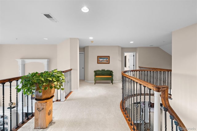 hallway with recessed lighting, carpet flooring, visible vents, baseboards, and an upstairs landing