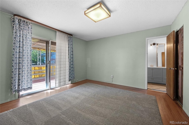 empty room featuring wood-type flooring and a textured ceiling