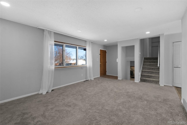 carpeted spare room with a textured ceiling