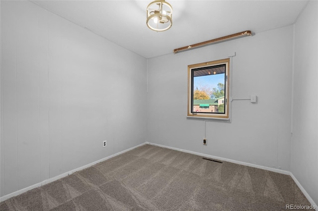 unfurnished room featuring carpet floors, visible vents, and baseboards