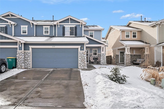 view of front facade with a garage, stone siding, and driveway